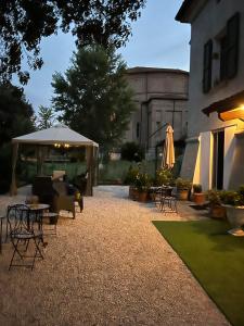 a patio with a table and chairs and an umbrella at Il Castello di Alberico in Cotignola