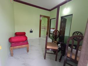 Zimmer mit einem Tisch, einem Stuhl und einem Spiegel in der Unterkunft Sili Homestay in Madikeri