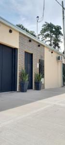 a building with two garage doors and two potted plants at EL HORNERITO Apart in Reconquista