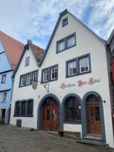 un edificio blanco con puertas y ventanas marrones en Gästehaus Alter Keller en Rothenburg ob der Tauber