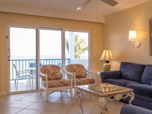 a living room with a couch and chairs and a table at Deluxe Sea View Villas at Paradise Island Beach Club Resort in Creek Village