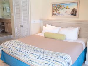 a bedroom with a large bed with white pillows at Deluxe Sea View Villas at Paradise Island Beach Club Resort in Creek Village