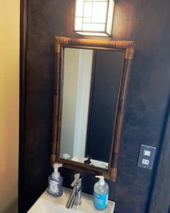 einen Spiegel an einer Wand über einem Waschbecken in der Unterkunft ＊THE CABIN 鎌倉＊鎌倉エリア/寛ぎのレトロなお部屋/ワンちゃんOK in Kamakura