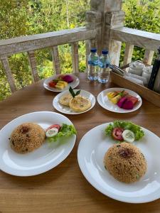 a wooden table with plates of food on it at Garden Terrace Bali in Gobleg