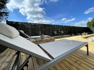 una terrazza in legno con panchina su un patio di Une Nuit Ailleurs a Le Locle