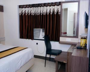- une chambre avec un lit et un bureau avec un ordinateur dans l'établissement Hotel Gopal, à Dwarka