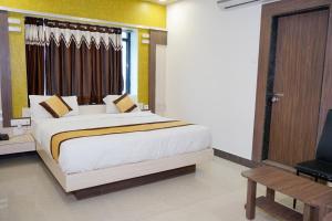 - une chambre avec un grand lit et une télévision dans l'établissement Hotel Gopal, à Dwarka