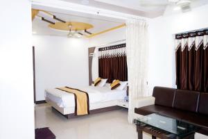 a bedroom with a bed and a couch at Hotel Gopal in Dwarka