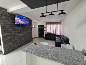 uma cozinha e sala de estar com televisão na parede em Casa Murillo em San José