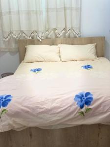 a white bed with blue flowers on it at Grandmother's House in Famagusta