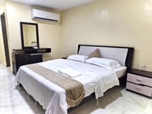 1 dormitorio con 1 cama blanca grande y espejo en Spring Tower, en Al Jubail