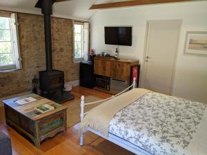 1 dormitorio con 1 cama y estufa de leña en Morialta Barns en Norton Summit