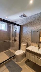 uma casa de banho com um chuveiro, um WC e um lavatório. em Casa La Silvinas Hotel & Event Resort em Tagaytay