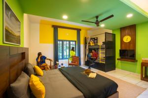 a bedroom with green and yellow walls and a bed at The Hosteller Wayanad in Vythiri