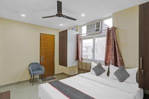 - une chambre avec un lit, une chaise et une fenêtre dans l'établissement Meera Eternity, à Noida