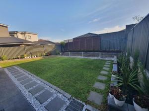 a backyard with a lawn with rocks and plants at Entire house, 5br luxury hideaway in Narellan
