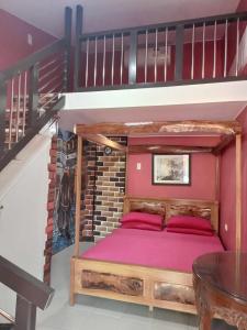een slaapkamer met een houten bed onder een hoogslaper bij Hiding Place Mission Farm in General Tinio