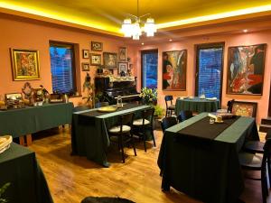 a restaurant with tables and a piano in a room at Art Pension dans le Parc in Banská Bystrica