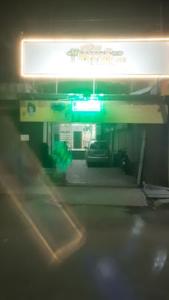 Hotel Parth Inn, WARDHA في Wardha: محطة وقود في الليل مع ضوء أخضر