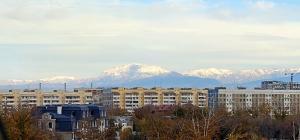 a city with snow capped mountains in the background at Elegant Condo next to Bazaar, close to the metro station, 9 in Tashkent