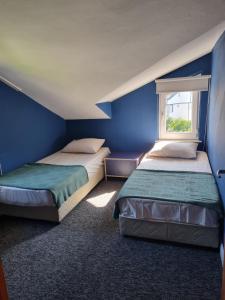 two beds in a room with blue walls and a window at Villa Xenia in Kemer