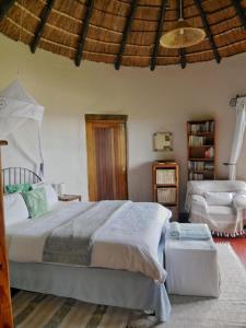 a bedroom with a large bed and a chair at Delicious Monster Accommodation in Port St Johns