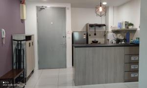 cocina con encimera, nevera y puerta en Leisure homestay@Sutera Avenue 2-1007, en Kota Kinabalu