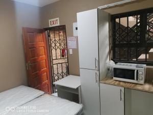 a kitchen with a refrigerator and a microwave on a counter at Kpt property investment in Soweto