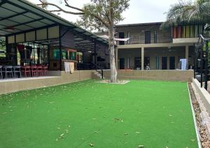 a house with a green lawn in front of a building at Bentong Wellness Resort Midland 8BR 30PAX By Verano Homestay in Bentong +7 photos