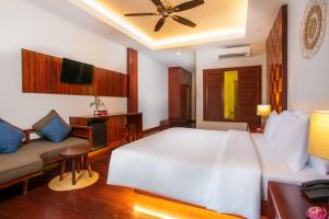a bedroom with a large white bed and a couch at Mera Residence in Siem Reap