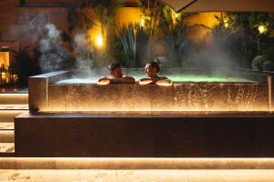 dos personas en una bañera de hidromasaje en un edificio en Hi Hotel - Wellness & Spa, en Trento