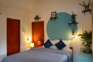 a bedroom with a bed with a blue wall at Terraria Stay and Cafe in Canacona