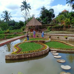 un jardín en medio de un estanque en Petak Homestay Ubud, en Penginyahan