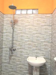 y baño con lavabo y ducha. en Petak Homestay Ubud, en Penginyahan