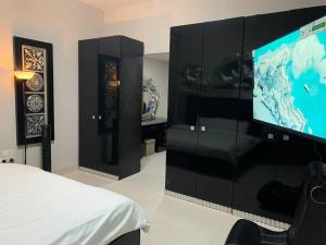 a bedroom with a flat screen tv on a wall at 2BR W Pool-20 min to DXB APT & Dubai Mall in Dubai