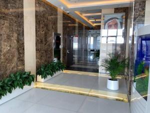 a lobby with potted plants in a building at 2BR W Pool-20 min to DXB APT & Dubai Mall in Dubai