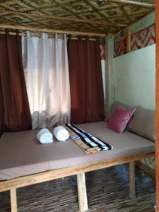 Una cama en una tienda con sombreros. en Chloe’s Paradise Hostel en Batuan