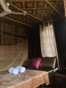 a room with a bed with two towels on it at Chloe’s Paradise Hostel in Batuan