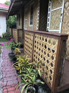 a wooden fence in front of a house with plants at Chloe’s Paradise Hostel in Batuan