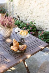 a table with a bowl of bread and a bowl of pastries at Theros Cottage Nafplio in Nafplio