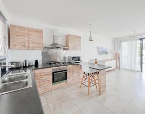 a kitchen with wooden cabinets and a counter top at Résidence Celestial - Premium 3 bedrooms Villa with volcanic stone Pool in Grand-Baie