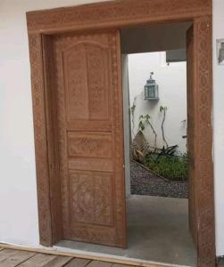 a wooden door in a room with a mirror at Le Dhow in Moroni