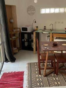 a kitchen with a wooden table and a table and chairs at Le Dhow in Moroni