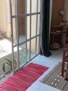 a room with an open glass door with a rug at Le Dhow in Moroni