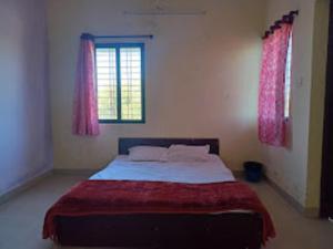 een slaapkamer met een groot bed en roze gordijnen bij Two Brother's Hotel lodging And Restaurant WARDHA in Wardha