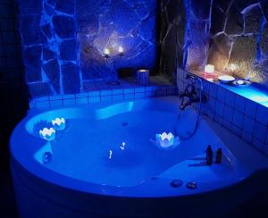 een blauw bad in een kamer met een stenen muur bij Luxury bnb Le Rocce in Villasmundo
