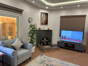 a living room with a television and a fireplace at فندق وفلل مون تري in Najran