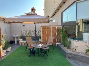 a patio with an umbrella and a table and chairs at شركه فندق مون تري الفندقيه شركه من شخص واحد in Najran