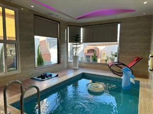 ein Haus mit einem Pool in einem Zimmer in der Unterkunft فندق وفلل مون تري in Najran