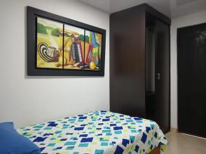 Un dormitorio con una pintura en la pared y una cama en HABITACIÓN INDEPENDIENTE y APARTAESTUDIO MONOAMBIENTE, en Barranquilla